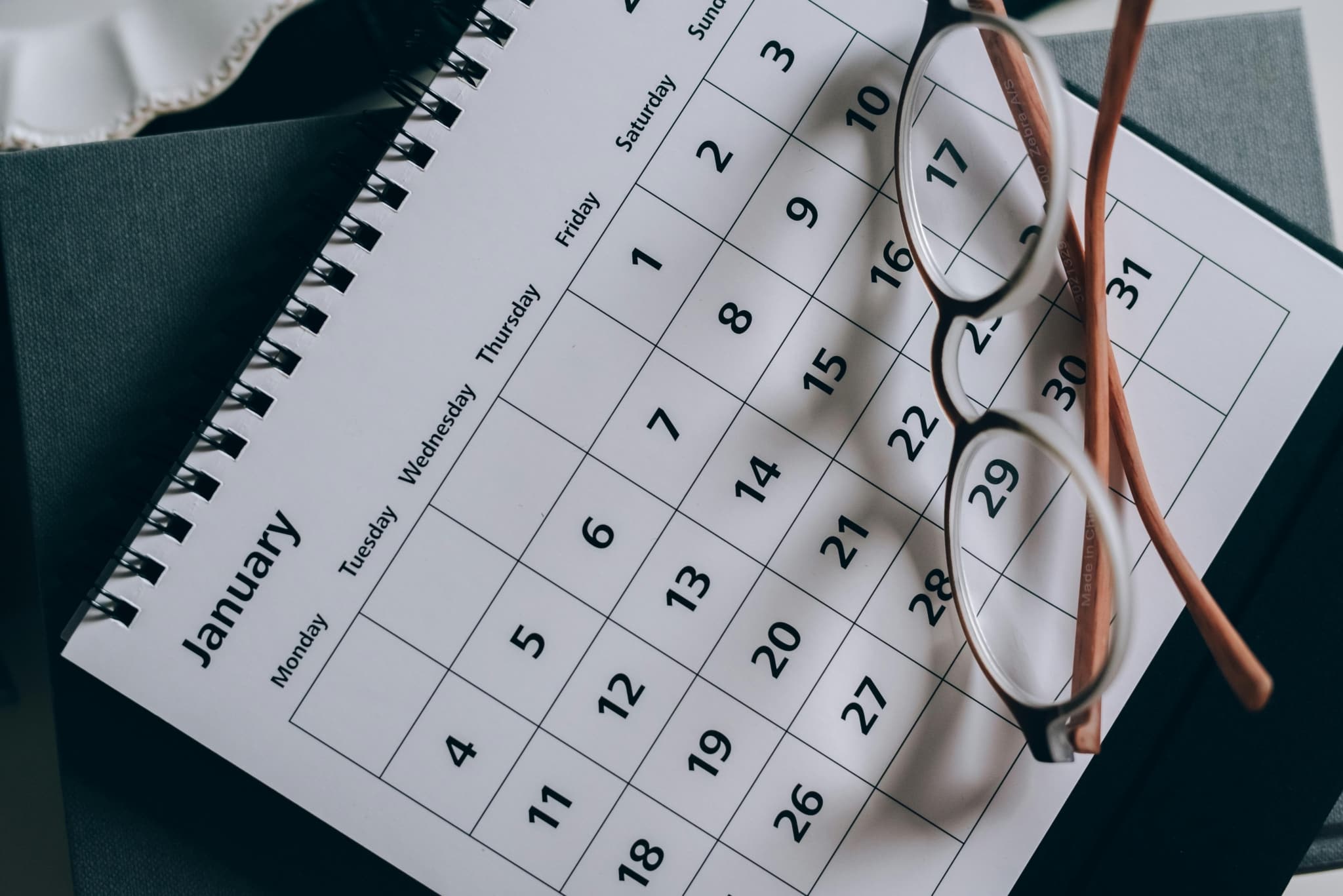 Calendar and glasses on desk